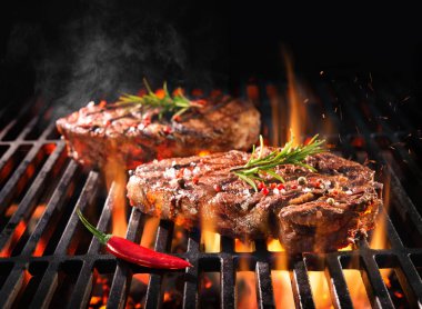 Beef steaks sizzling on the grill clipart