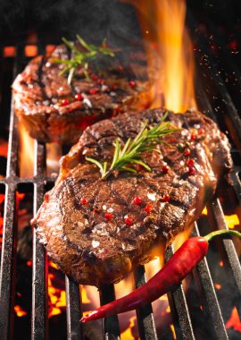 Beef steaks sizzling on the grill clipart