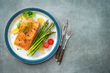 Izgara somon biftek yeşil kuşkonmaz, limon ve t ile süslenmiş