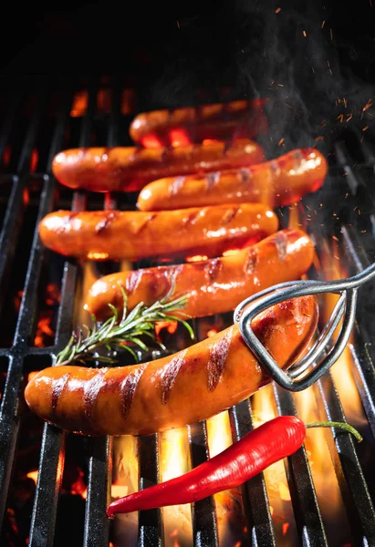 美味的香肠在烤肉架上的煤上喷火 — 图库照片