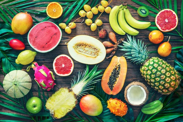 Sortimento de frutas tropicais com folhas de palmeiras e exot — Fotografia de Stock