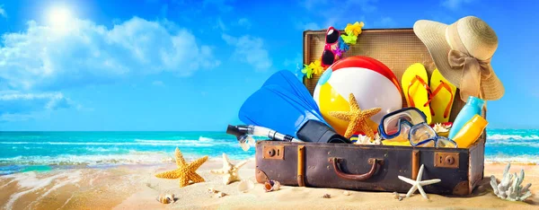 Strand accessoires in koffer op zand. Familie vakantie concept — Stockfoto