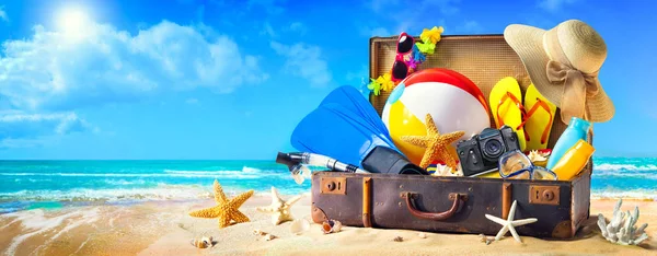 Beach accessories in suitcase on sand. Family holidays concept — Stock Photo, Image