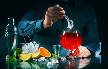 Barmen gece kulübünde Campari portakal kokteyli yapıyor.