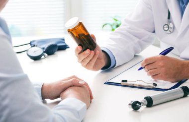 Doktor, kadın hastaya haplar hakkında danışmanlık yapıyor ve resepsiyonda oturan sağlık tedavisini engelliyor. İlaç ve sağlık hizmetleri kavramı