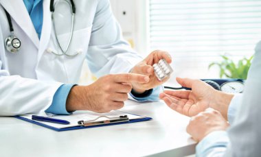 Doktor, kadın hastaya haplar hakkında danışmanlık yapıyor ve resepsiyonda oturan sağlık tedavisini engelliyor. İlaç ve sağlık hizmetleri kavramı