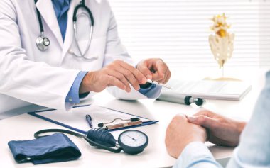 Doktor, kadın hastaya haplar hakkında danışmanlık yapıyor ve resepsiyonda oturan sağlık tedavisini engelliyor. İlaç ve sağlık hizmetleri kavramı