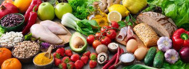 Ahşap masanın üzerinde çeşitli organik gıda ürünleri var. Sağlıklı gıda konsepti