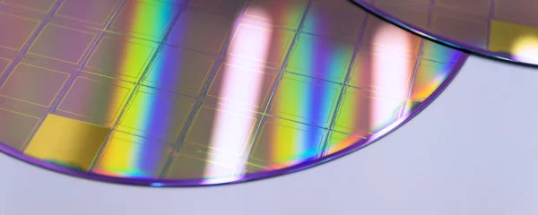 Silicon Wafers and Microcircuits - semiconductor material, such as a crystalline silicon. Detail of a silicon chip wafer reflecting different colors