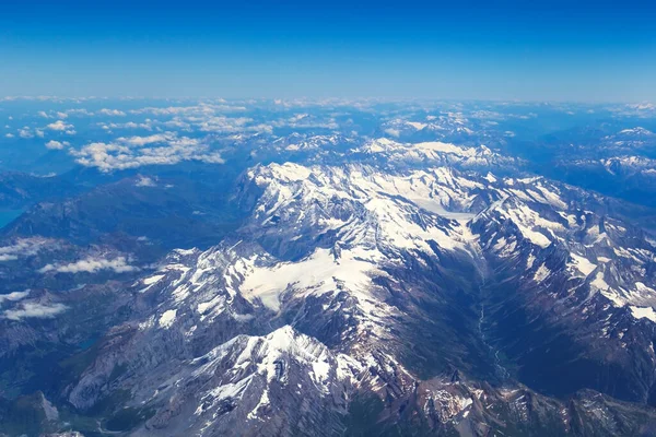 飛行機の窓からのアルプスの山々の空の景色絵のように美しい山々の風景の上の飛行機の窓からの眺め — ストック写真