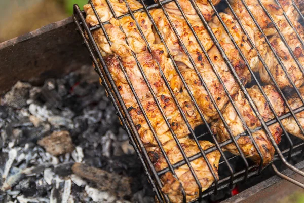 Poulet grillé sur le gril. Processcooking cuisses de poulet sur un barbecue grill extérieurflammes et fumée sur le fond. — Photo