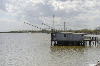 lagün üzerinde büyük fishnet ile eski geleneksel stilt balıkçı kulübesi, Comacchio parlak bahar güneş ışığında vuruldu, Ferrara, İtalya