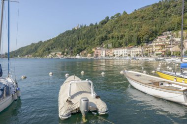 manzara, yeşil Garda Gölü kıyısına demirli teknesinde parlak sonbahar ışık vurdu Toscolano Maderno, Brescia, Ital ördekle turistik Köyü'nde