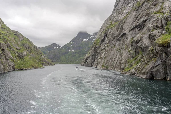 Turistický člun vstupuje do brázdy parníku v úzkém fjordu, Trollfjo — Stock fotografie