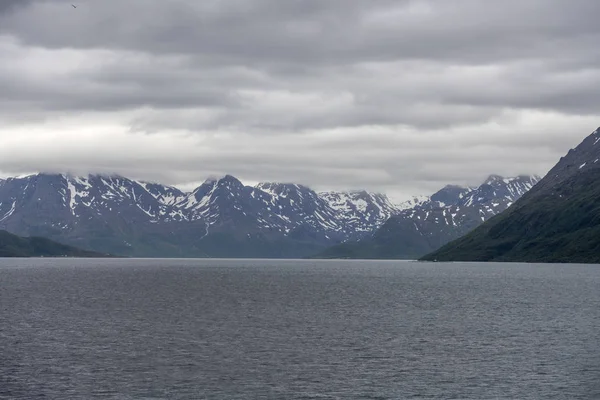 Sommar snö och ljusa moln i norra fjorden nära Soroya isla — Stockfoto