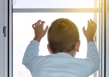 Çocuk açık pencere ve cibinlik üzerinde tutar. Bir pencereden dışarı düşmesini bir çocuk koruma kavramı