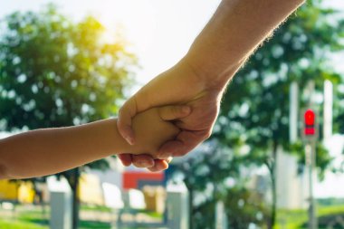Bir yaya geçidi adlı bir çocuk koruma kavramı. Bir trafik ışığı, bir geçiş. Babası oğlunun elini tutar