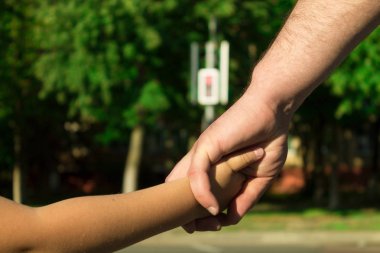 Bir yaya geçidi adlı bir çocuk koruma kavramı. Bir trafik ışığı, bir geçiş. Babası oğlunun elini tutar