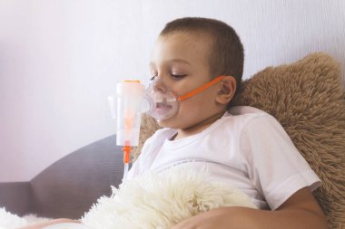 Bir çocuk bir Nebulizatör evde yatakta soluk