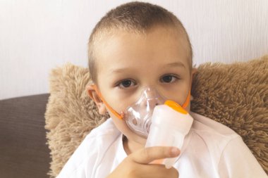 Bir çocuk bir Nebulizatör evde yatakta soluk
