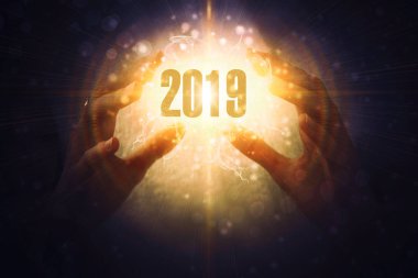 sihirli bir parıltı, bir ışık karanlık bir arka plan karşı kadın elinde 2019