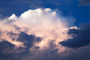 Gök gürültüsü fırtına öncesi mavi-pembe bulutlar. Arka planı karanlık fırtına bulutları havada.