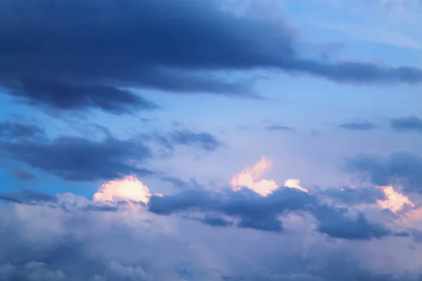 Blue-pink clouds before a thunder-storm. Background of the sky in dark storm clouds.