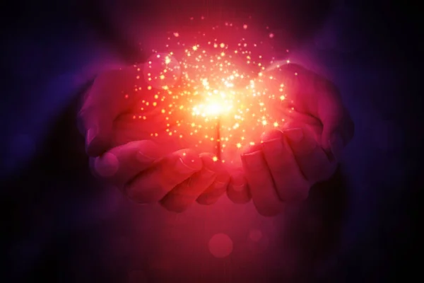 Sihirli parçacıklar, karanlık bir arka plan üzerinde eller yakın çekim gelen enerji akışını