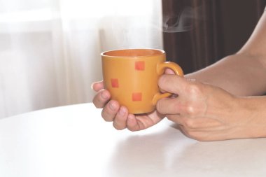 Turuncu fincan sıcak kahve kadının elinde yakın çekim