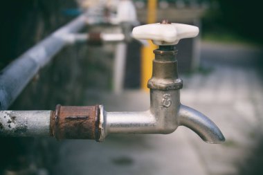 Eski paslı sokak musluk yakın çekim dokunun. Bir satır sokak su vinç