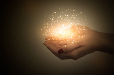 bir kadın, kadın elinden yayılan büyülü enerji akışı avuç üzerinde sihirli parçacıklar