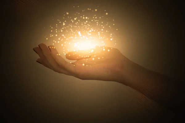 bir kadın, kadın elinden yayılan büyülü enerji akışı avuç üzerinde sihirli parçacıklar
