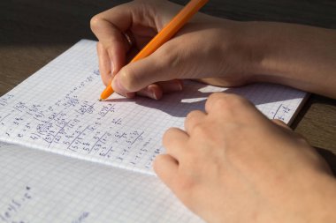 Bir el matematiksel formüller bir defterde yazar. Okul ödevi, matematik