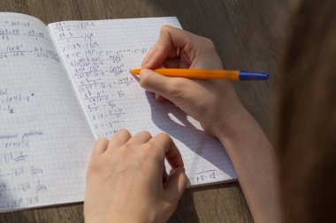 Bir el matematiksel formüller bir defterde yazar. Okul ödevi, matematik