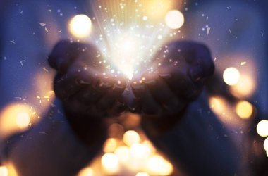Sihirli eller yayılan parçacıklar. Bokeh ile Noel arka plan