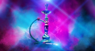 Boş bir oda arka plan üzerinde nargile sigara. Çok renkli neon ışık. Projektör, lazer ışınları, mavi ve pembe duman.