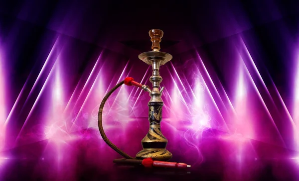 Smoking hookah on the background of an empty room. Multicolored neon light. Searchlight, laser blue and pink rays, smoke. — Stock Photo, Image