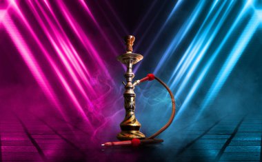 Nargile, karanlık soyut bir arka planda duman. Çok renkli neon ışıkları ile boş sahnelerin arka plan, ıslak kaldırım üzerinde gece ışıkları yansıması