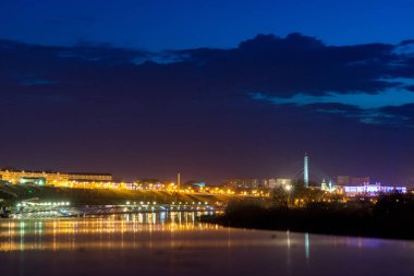 Görünüm güneş battıktan sonra Tyumen set of. Işıklar granit ve nehir yansımaları.