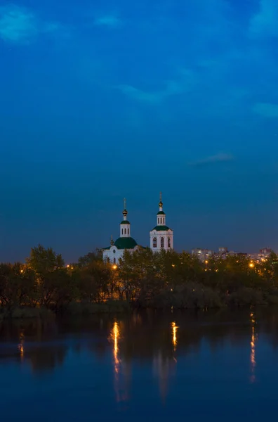 stock image Christian Church after sunset stands near the river. Ascension-St. George Church in Tyumen.