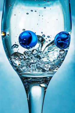 Bardağında ulaşan iki cam top float, birçok hava kabarcıkları oluşturma.