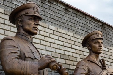 Bronz anıt deniz formunda iki adam şeklinde. Onlardan biri onun elinde dürbün ile bir Kaptan, diğer bir dümenci. Bir tuğla duvara yaslan. Volga işçilerin anıt.