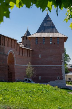 Kule kırmızı tuğla bir duvara, yaprak ve ot bir çerçeve ile bir Antik sur var. Duvar kemer. Araba binanın yanındaki.