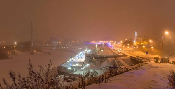 雪に覆われた冬の夜にチュメニの堤防の様子夜の街の明かり 恋人たちの橋 — ストック写真