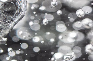 Kaynama hava kabarcıkları tuhaf bir form alır. Metalik bir şenliği olan soyut figür. Arka planda çok sayıda ışık noktası.