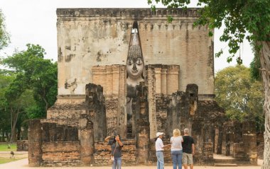 Turist ziyaret eski Buddha heykeli Sukhothai Tayland