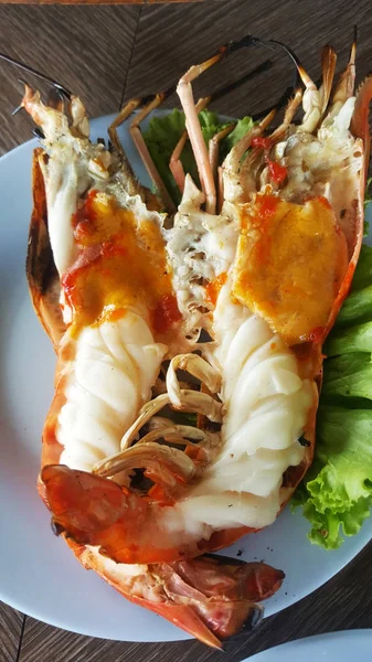 roasted shrimps in plate with salad on table