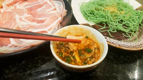 Eten en dompelen varkensvlees met saus in een restaurant — Stockfoto