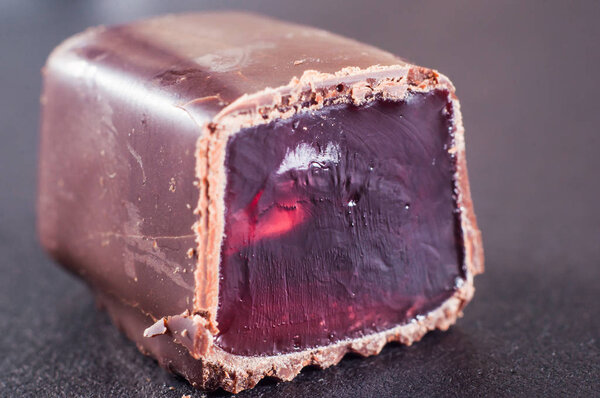 Jelly candy drenched in chopped chocolate. Red, pink dye in gela