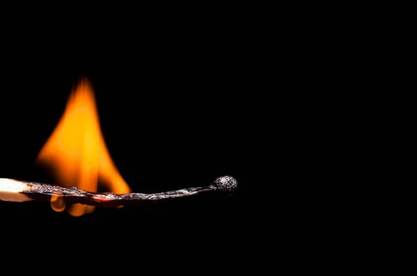 Burning-down wooden match close-up, on a black background. Isola — Stock Photo, Image
